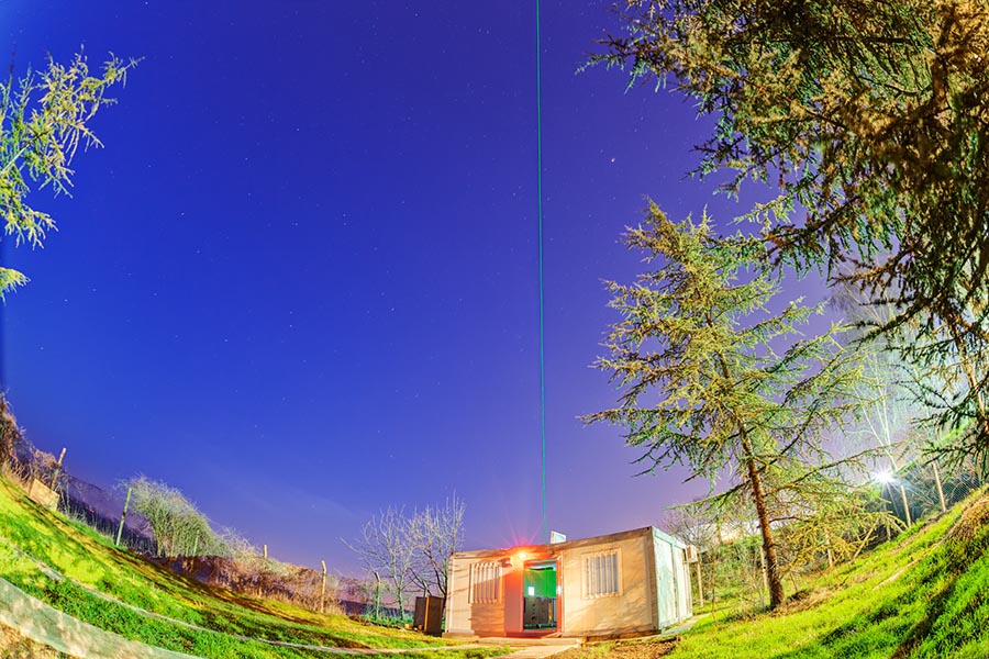 Photo of a lidar facility emitting a laser into the sky
