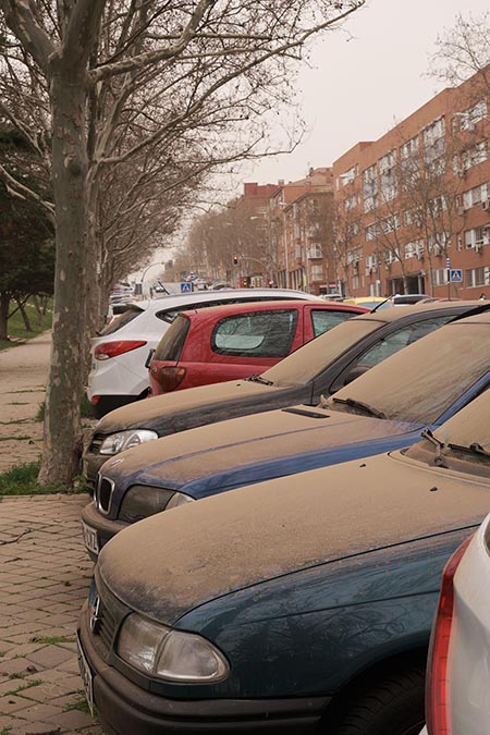 Cars covered in a layer of reddish dust