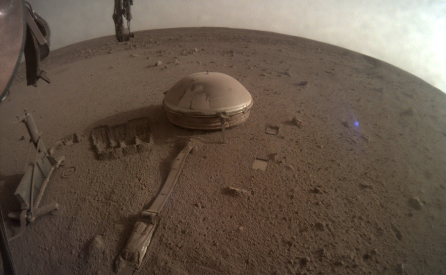 A fisheye view of Mars from the InSight lander where everything is covered in brown dust.
