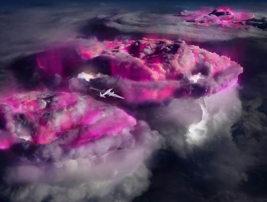 A plane flies over pink and purple thunderstorm clouds.