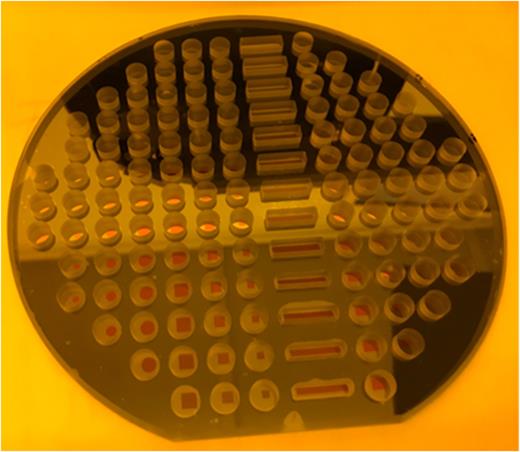 FIG. 3. Fully processed 150 mm wafer stack 6 mm thick containing 120 individual vapor cells with a range of aperture sizes and dielectric mirror configurations. The cell windows are clear of CsN3 crystal residue.