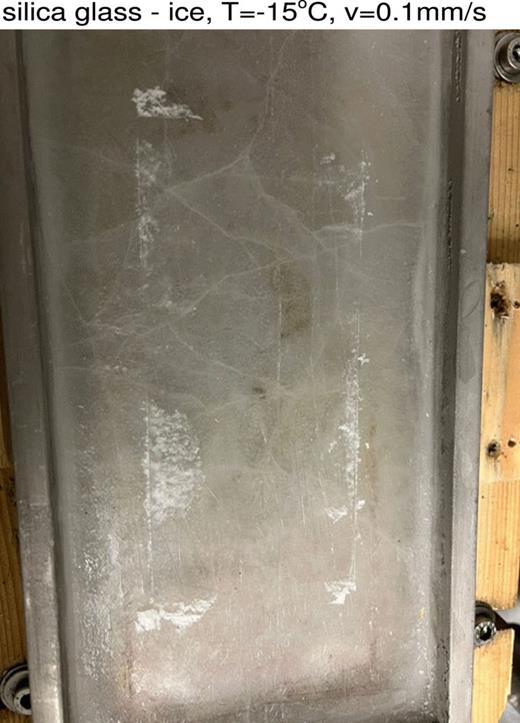 Ice surface after sliding in Fig. 15. Note the ice wear particles (white powder).