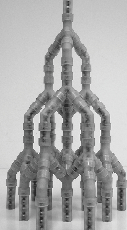 Figure 4. This impact-dispersing granular network consists of branching one-dimensional chains of stainless steel spheres, each 1 cm in diameter, contained in a surrounding polymer matrix.12 The 1D chains in each branch support the formation and propagation of solitary waves, which are partially reflected and partially split at each branching point. The result is an exponential decay of the wave in both the lateral and vertical orientation of the photograph. (Courtesy of Andrea Leonard.)