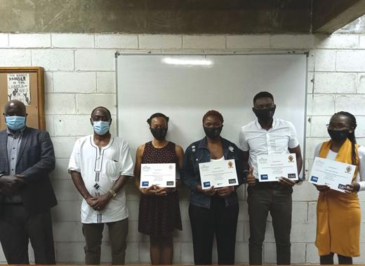  . The winning team at the hybrid remote–on-site hackathon hosted last September by the University of Zambia used Twitter data to analyze whether people view COVID-19 as a hoax. From left, lecturer Habatwa Mweene, dean of natural sciences Onesmus Munyati, and the winning student team of Esther Mungalaba, Mudenda Sakala, Emmanuel Hansingo, and Clemens Chama. 