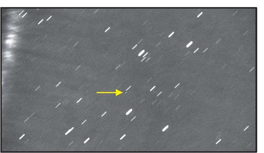 Figure 4. A Vatira on film. The Virtual Telescope Project took this image on 8 January 2020. It shows the average of 14 60-second exposures. They were combined to track the motion of 2020 AV2—the white dot, marked by an arrow—across the sky to reveal the asteroid as a point source, against which the stars streak. (Image courtesy of Gianluca Masi, Virtual Telescope Project.) 