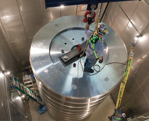 Figure 5. Riggers working on the roughly four-story weight stack of the NIST million-pounds-force deadweight machine. (Courtesy of NIST.) 