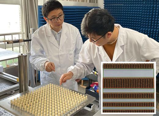 Figure 1. A photonic crystal made of dielectric posts surrounded by air transmits different wave modes than either material alone. Yun Lai (left) and his postdoc Hongchen Chu (right) are shown here with one such metamaterial. Alternating regions of air and photonic crystal forms a waveguide array with no separation between adjacent channels (inset). The photonic crystal, which has 3.6 × 2.4 mm posts, and the air host disjoint sets of wave modes, so light doesn’t cross the boundary between them. (Photo courtesy of Cong Wang; inset adapted from ref. 1.) 